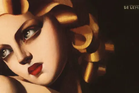 Portret kobiety z burzą złotych loków i wyrazistymi czerwonymi ustami, dzieło tamara łempicka.